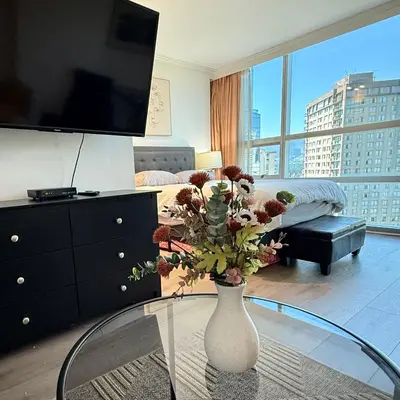 a living room with a vase with flowers on a glass table at Sea to Sky Studio with Mountain and City Views in Vancouver
