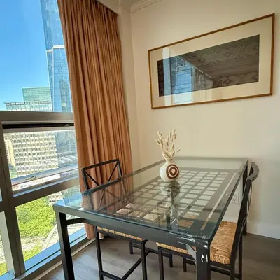 a dining room with a glass table and a window at Sea to Sky Studio with Mountain and City Views in Vancouver