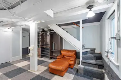 a living room with a staircase and a brown chair at Adorable Kits Home with Balcony and Garden Retreat in Vancouver