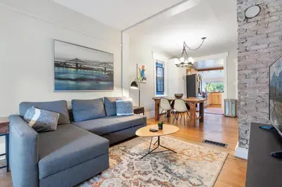 a living room with a couch and a table at Adorable Kits Home with Balcony and Garden Retreat in Vancouver