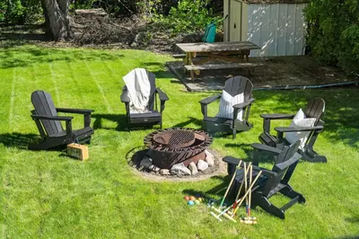 a group of chairs and a fire pit in a yard at Kinepik Cottage Sunroom with Beach Access in Sylvan Lake