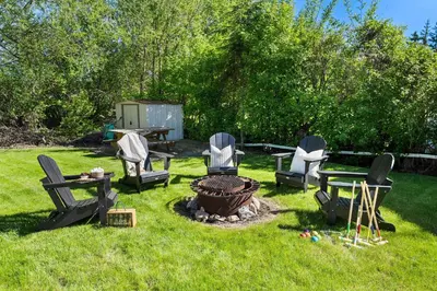 a group of chairs and a fire pit in a yard at Kinepik Cottage Sunroom with Beach Access in Sylvan Lake