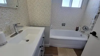 a bathroom with a sink and a tub and a toilet at 4-Bedroom Home by Downtown and Airport in Calgary