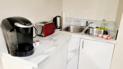 a kitchen counter with a coffee maker and a sink at 4-Bedroom Home by Downtown and Airport in Calgary