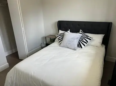 a white bed with four pillows on top of it at Cozy 3-Bedroom Retreat in Surrey Share Save in Surrey