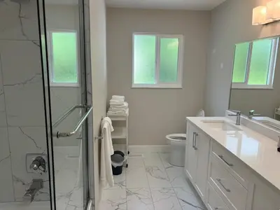 a white bathroom with a shower and a toilet at Cozy 3-Bedroom Retreat in Surrey Share Save in Surrey