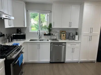a kitchen with white cabinets and a sink at Cozy 3-Bedroom Retreat in Surrey Share Save in Surrey