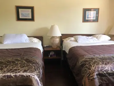 a hotel room with two beds and a lamp at Villagers Inn in Fruitvale