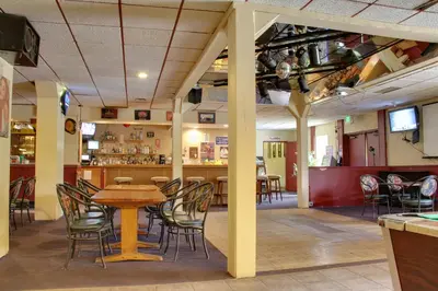 a restaurant with a table and chairs and a bar at Villagers Inn in Fruitvale