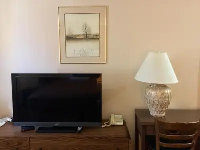 a flat screen tv sitting on a table next to a lamp at Villagers Inn in Fruitvale