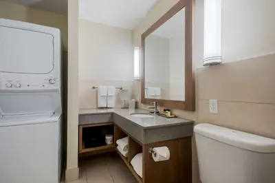 a bathroom with a sink and a toilet and a mirror at Best Western Plus Sawridge Suites in Fort McMurray