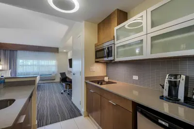 a kitchen with wooden cabinets and a counter top at Best Western Plus Sawridge Suites in Fort McMurray