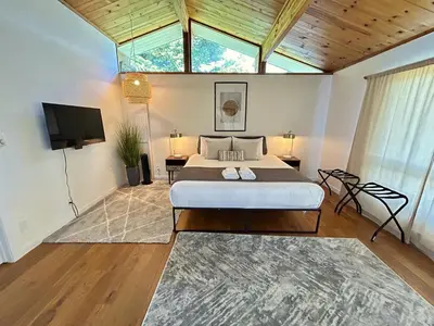 a bedroom with a bed and a flat screen tv at Ocean's Embrace Suite in Nanaimo
