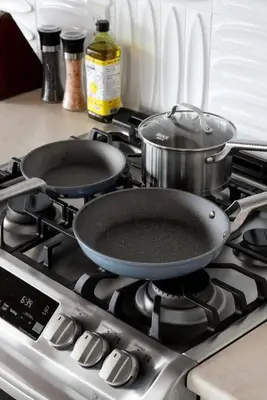 two pans sitting on top of a stove at Ocean's Embrace Suite in Nanaimo
