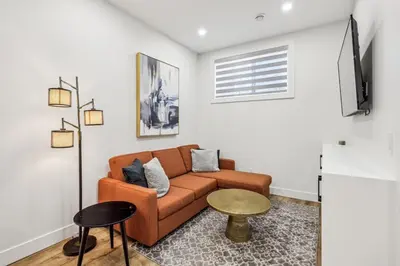 a living room with a couch and a tv at Ultimate Group Stay, 3 King Beds, 2 Suites in Calgary