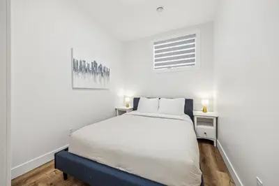 a white bedroom with a bed and a desk at Ultimate Group Stay, 3 King Beds, 2 Suites in Calgary