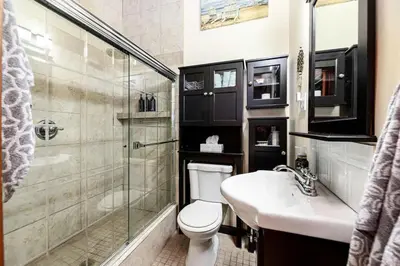 a bathroom with a toilet and a shower and a sink at Sylvan Cabin - 3 BR Family Fun Luxurious Yard in Sylvan Lake