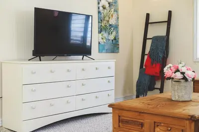 a white dresser with a television on top of it at Sylvan Cabin - 3 BR Family Fun Luxurious Yard in Sylvan Lake