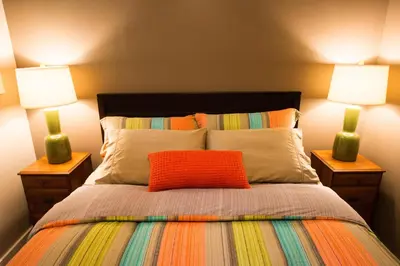 a bedroom with a bed with two lamps on it at Skeena River House Bed & Breakfast in Terrace