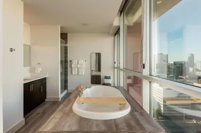 a bathroom with a tub and a large window at 2 Storey Penthouse Panoramic Views Parking Stampede in Calgary