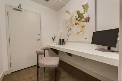 a room with a desk with a monitor and a chair at 2 Storey Penthouse Panoramic Views Parking Stampede in Calgary