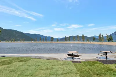 two picnic tables in front of a lake at Harrison Hot Springs Lakeside in Harrison Hot Springs