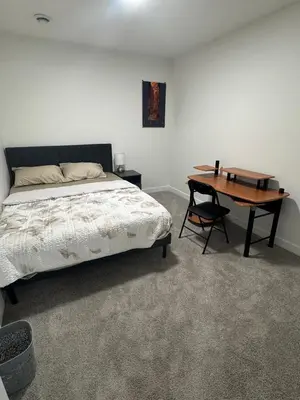 a bedroom with a bed and a wooden desk at The Nesting Cove in Airdrie