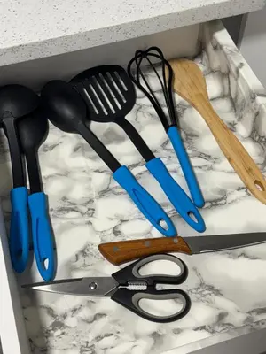 a drawer filled with kitchen utensils on a marble counter at The Nesting Cove in Airdrie