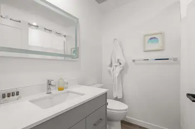 a white bathroom with a sink and a toilet at Central Kelowna TOP FLOOR rooftop patio in Kelowna