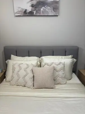 a bed with a bunch of pillows on it at Relax in Comfort, AC, YYC, CrossIron Mills, Banff in Calgary