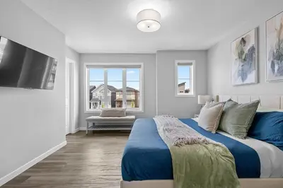 a bedroom with a bed and a flat screen tv at Relax in Comfort, AC, YYC, CrossIron Mills, Banff in Calgary