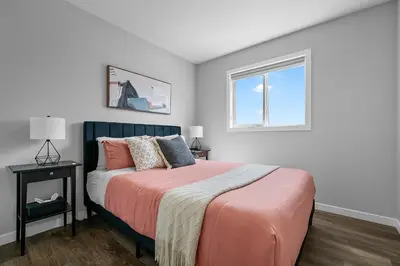 a bedroom with a bed and a window at Relax in Comfort, AC, YYC, CrossIron Mills, Banff in Calgary