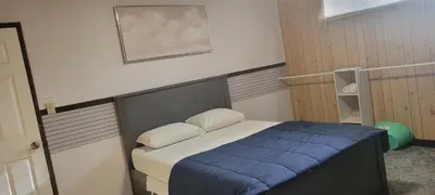a bedroom with a bed with a blue blanket at WhiteCourt in Abbotsford