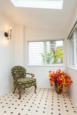 a room with a chair and a vase of flowers at Bright & Spacious House Near UBC in Vancouver