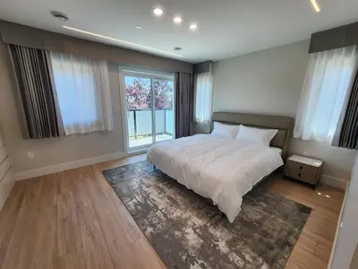 a bedroom with a bed and a large window at Luxury 3-Bedroom Home Modern Retreat in Vancouver in Vancouver