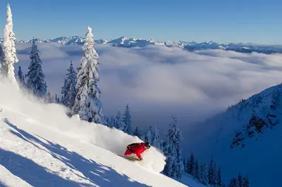 a person riding a snowboard down a snow covered slope at New Vaulted Ceilings 3 Beds AC Views in Golden