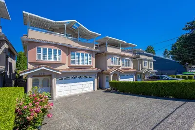a large pink house with a garage at 2 Bds suite beautiful Yard near PNE in Vancouver