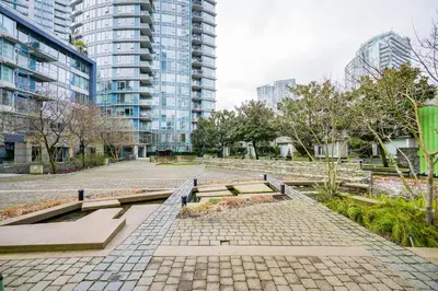a park with benches in a city with tall buildings at Gorgeous Unit with City Views in Vancouver