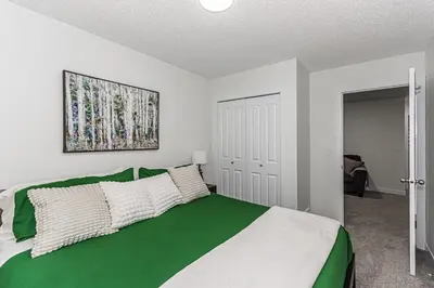 a bedroom with a large green and white bed at Escape in Style, River Cree, Netflix, Near WEM in Edmonton
