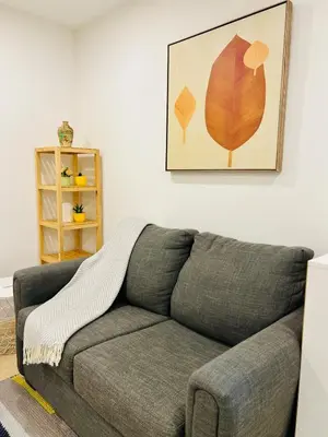 a couch with a blanket on it in a living room at Modern 2bd suite near Langley Events Centre in Langley