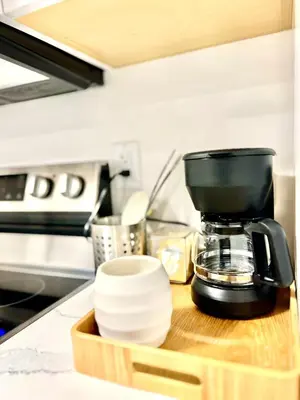 a kitchen counter with a coffee maker on a wooden tray at Modern 2bd suite near Langley Events Centre in Langley
