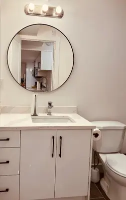a bathroom with a white sink and a mirror at Modern 2bd suite near Langley Events Centre in Langley