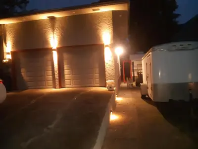 a garage with two garage doors at night with lights at Gordon Head Bed & Breakfast 2 Bathroom 4TV 5 Beds, Private Yard, Kids Gym & Games, Breakfast, WorkStn, Laundry, Kitchen in Victoria