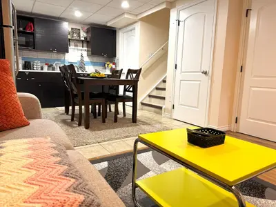 a living room with a table and a kitchen at Entire Walkout Basement Suite 2 BDRM King & Queen Patio Prvt Entrance in Edmonton