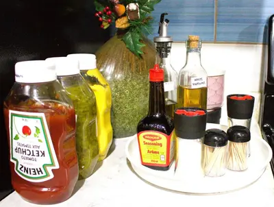 a counter topped with bottles of ketchup and mustard at Entire Walkout Basement Suite 2 BDRM King & Queen Patio Prvt Entrance in Edmonton