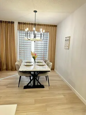a dining room with a table and chairs and a chandelier at Relax at The Hills at Ellerslie in Edmonton