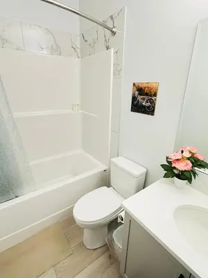 a white bathroom with a toilet and a sink at Relax at The Hills at Ellerslie in Edmonton