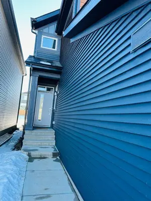 a blue house with a blue door and stairs at Relax at The Hills at Ellerslie in Edmonton