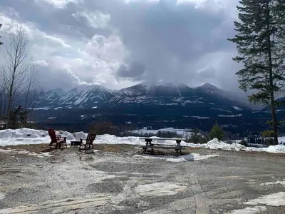 two benches in a parking lot with mountains in the background at Uncle Bills Cabin Entire home 6 min south of town in Golden