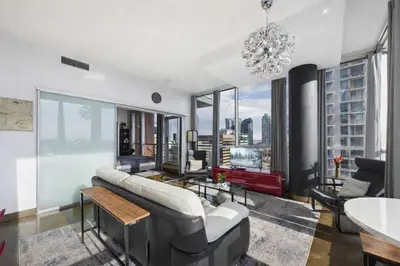 a living room with a couch and a chandelier at Modern Beltline Escape Sky-High Views DT Views in Calgary